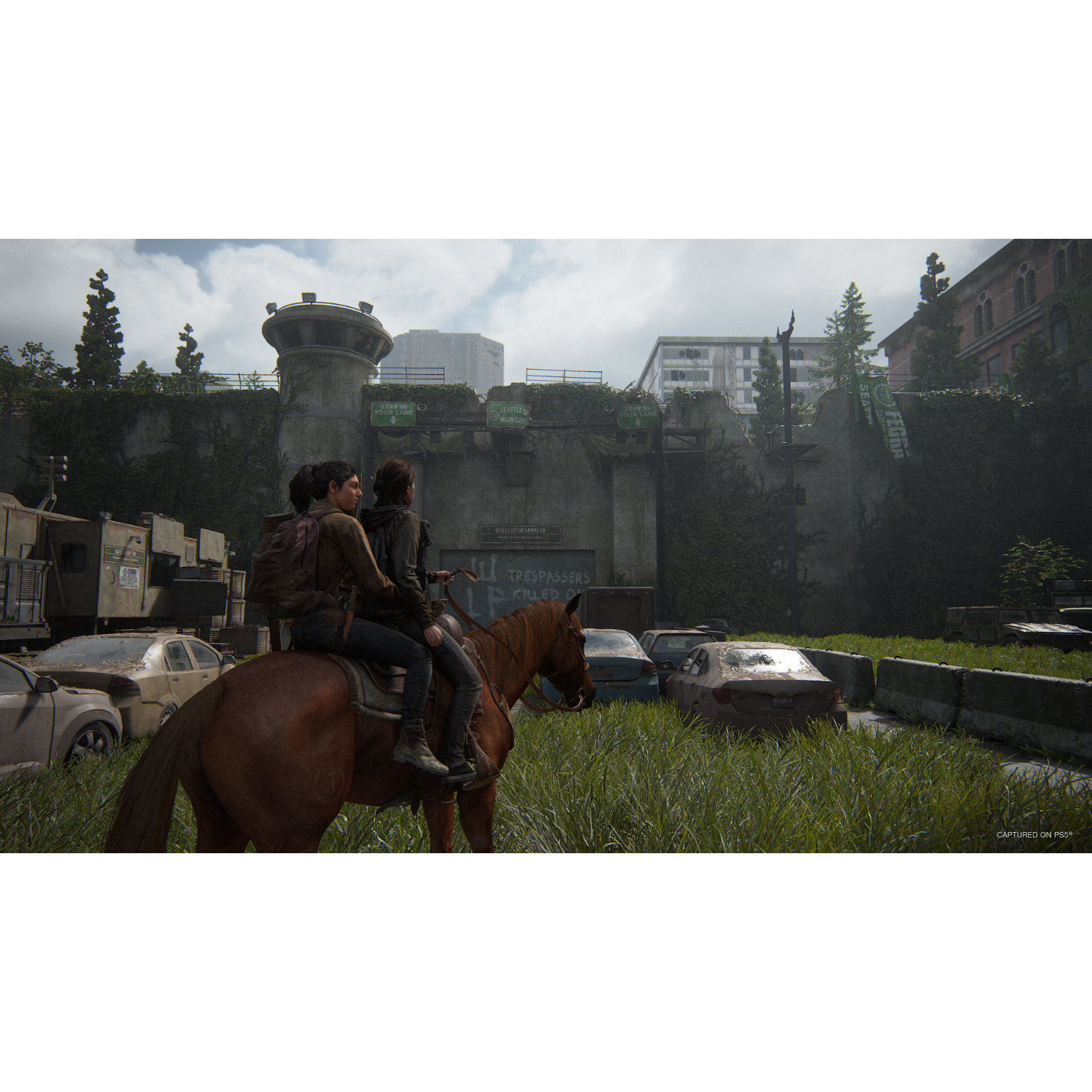 Two people riding a horse through a destroyed city, with a gate in the background.