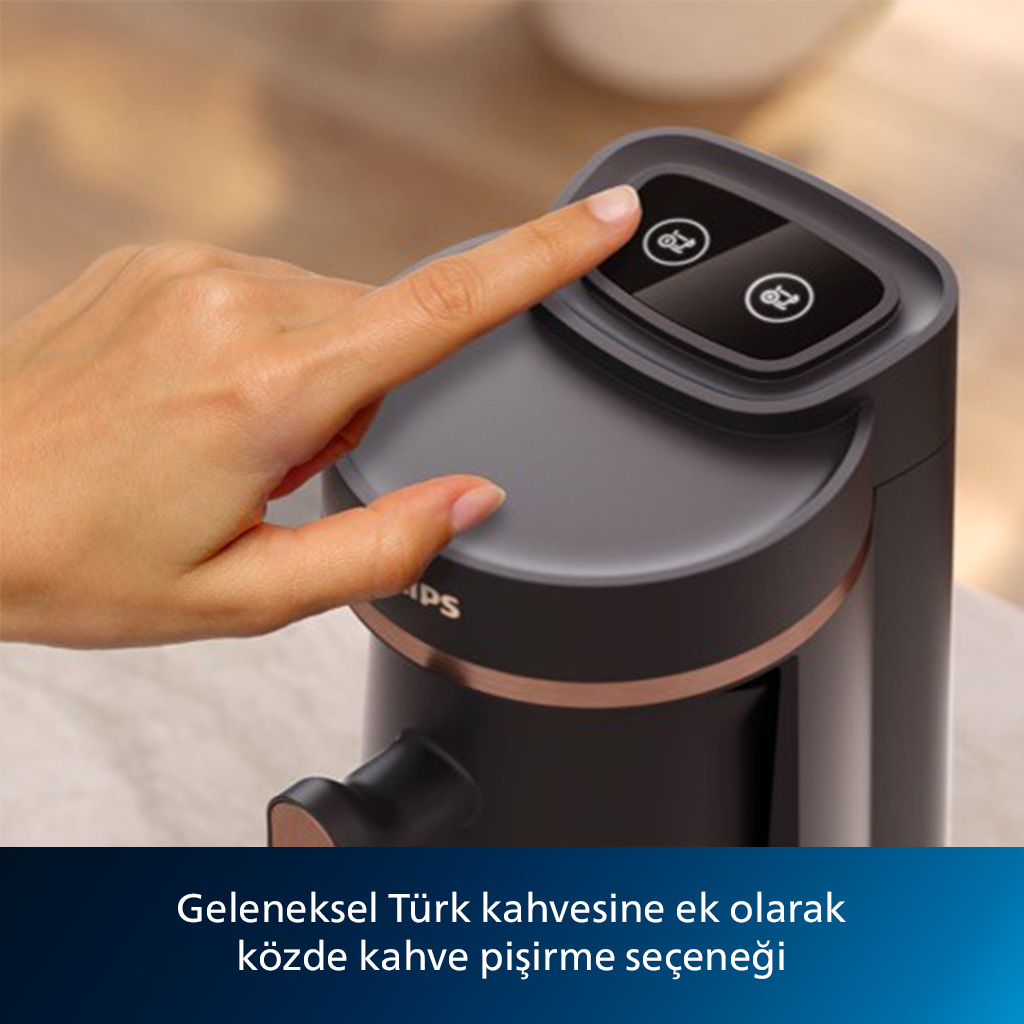 Bir kişinin eli bir kahve makinesine dokunuyor. Makine, altın rengi bir vurgu ile koyu gridir.