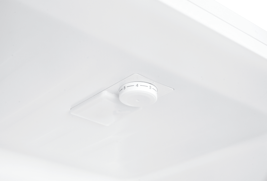 Primer plano del interior de un refrigerador blanco con un dial de control de temperatura.