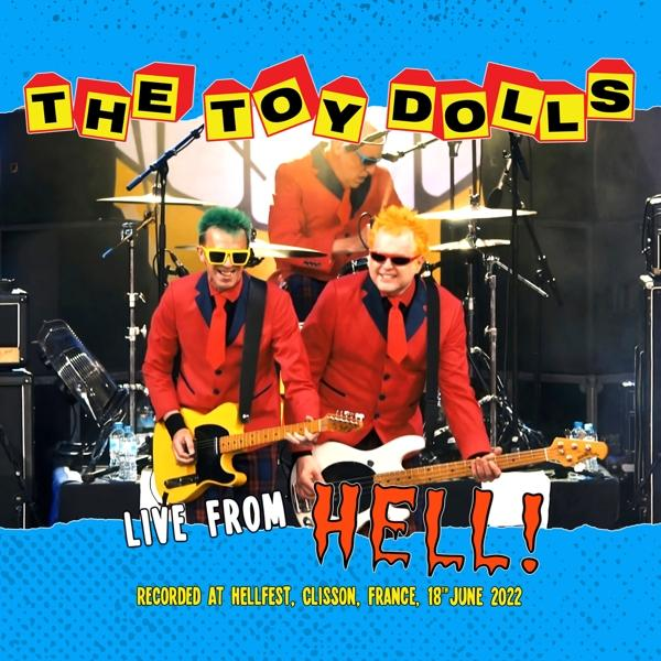 Egy zenekar élőben játszik, egy kék-sárga poszterrel, melyen a 'THE TOY DOLLS' felirat látható.