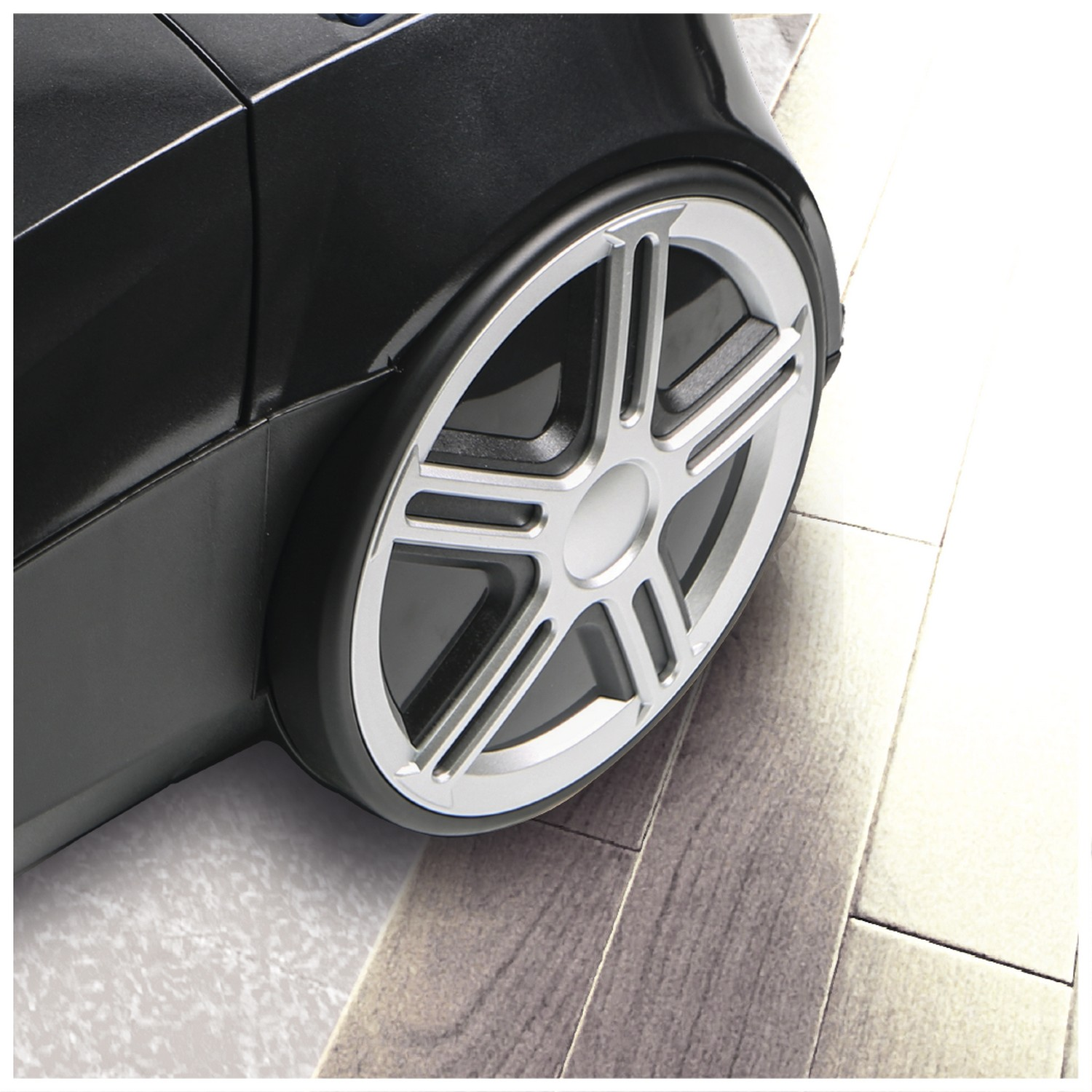 Close-up of a vacuum cleaner wheel. The wheel is silver and black.