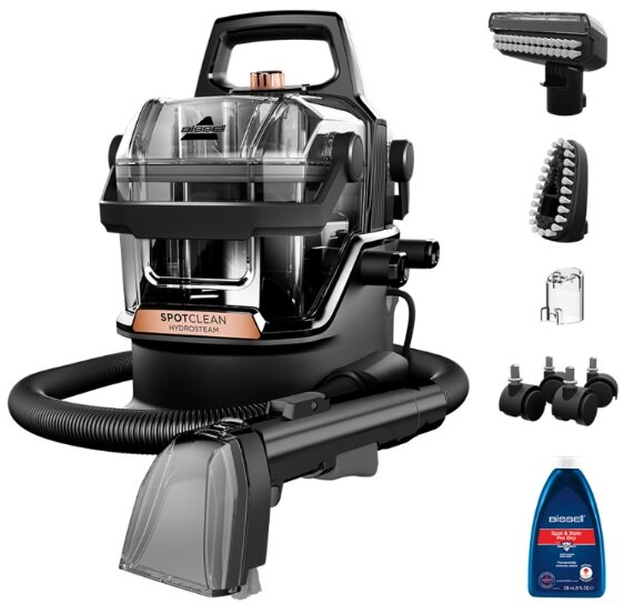 Bissell SpotClean HydroSteam. Czarna i przezroczysta maszyna z przystawkami. Widoczna butelka roztworu czyszczącego.