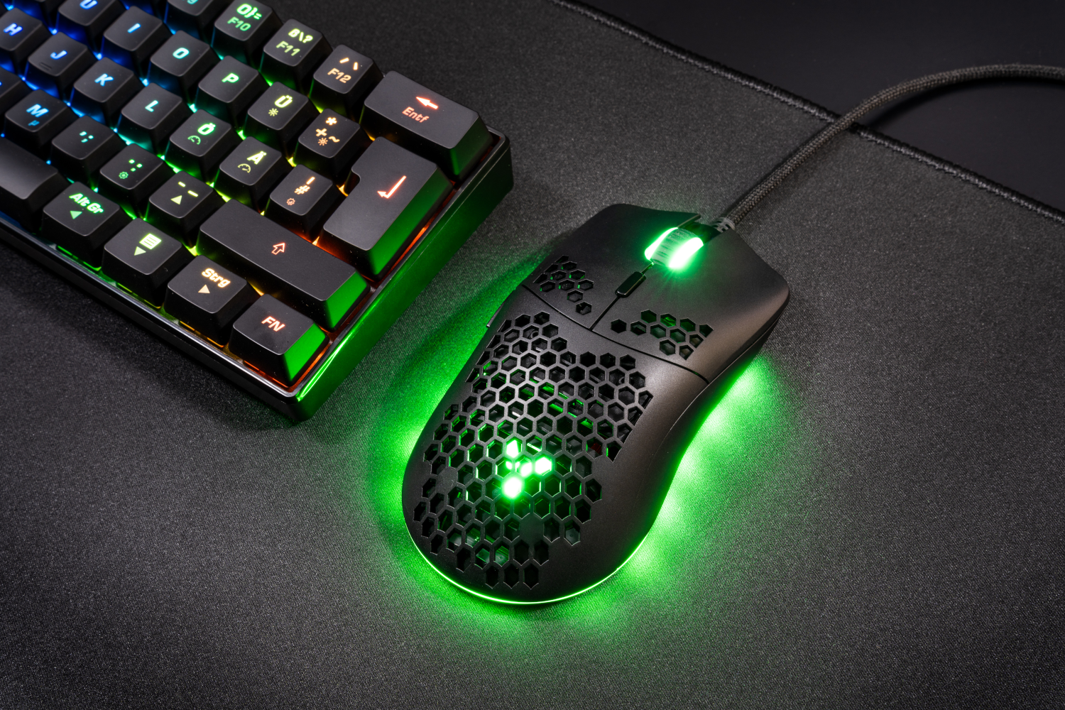 Fekete gamer egér méhsejtmintával és zöld világítással.