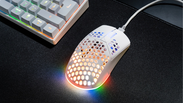 Fehér gamer egér méhsejtmintával és RGB világítással, fekete egéralátéten.
