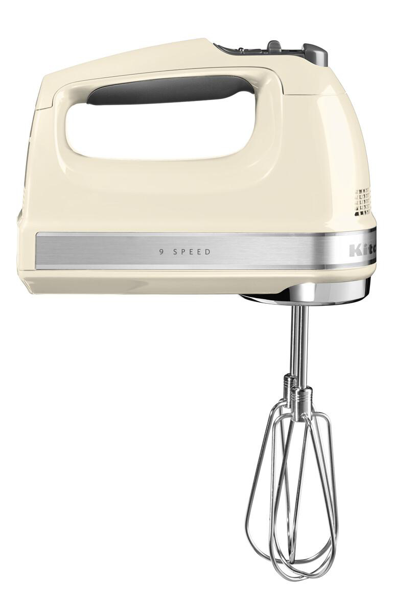 Ein cremefarbener Handmixer mit einem silbernen Band und Quirlaufsätzen.