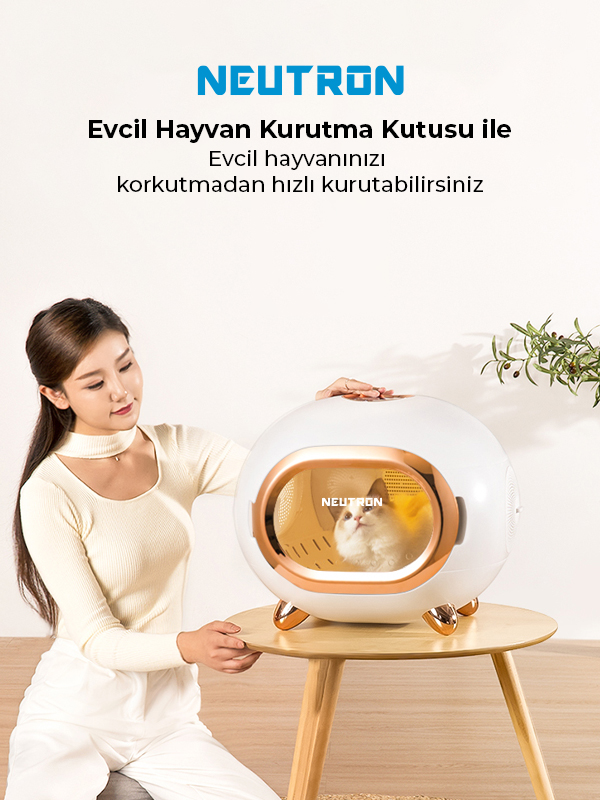 Bir kadın, içinde bir kedi bulunan beyaz bir evcil hayvan kurutucusuna bakıyor. Marka adı üzerinde.