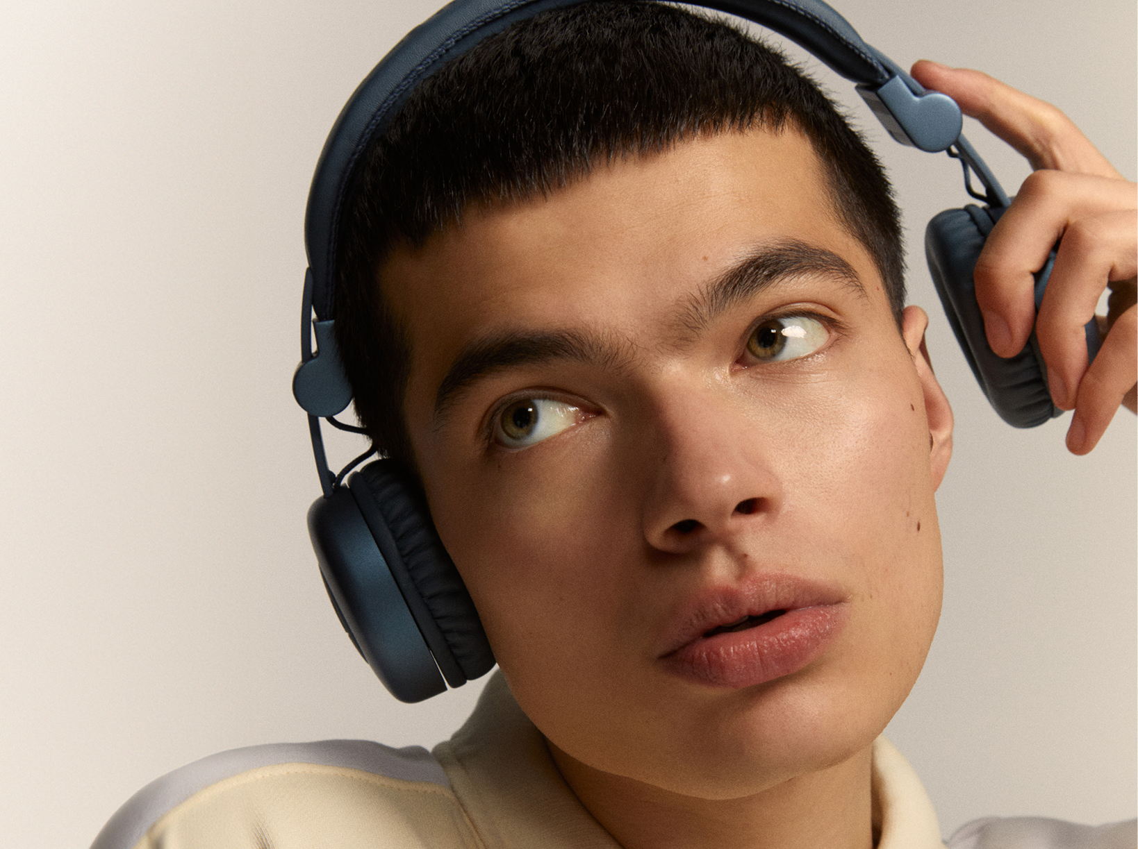 Un jeune homme avec un casque, regardant vers le haut et sur le côté.