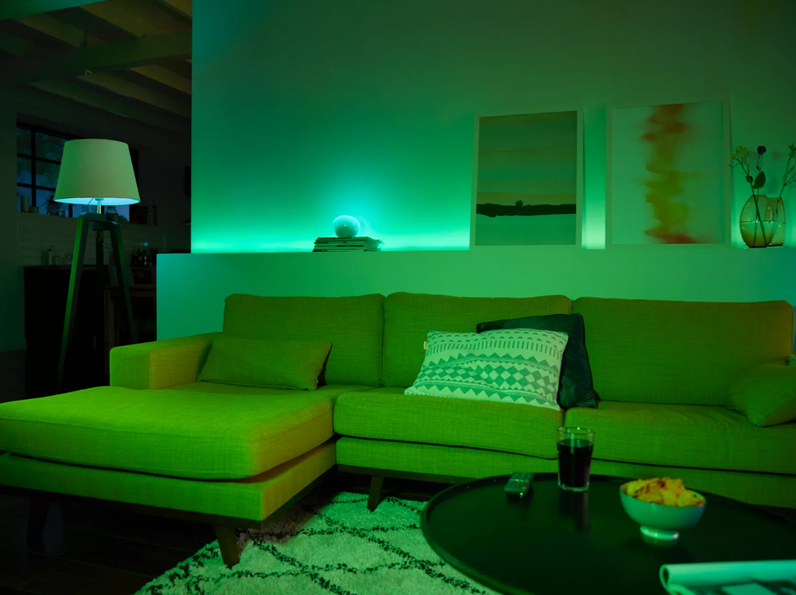 Stanza illuminata di verde con un divano e arte.
