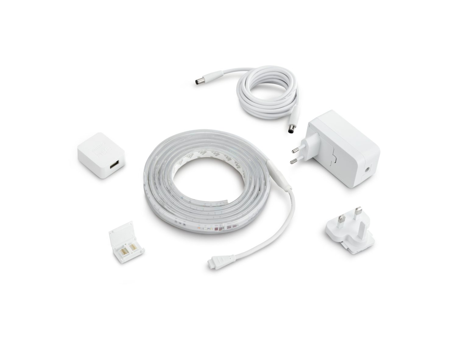 Striscia luminosa a LED bianca, adattatore di alimentazione e altri accessori su sfondo bianco.