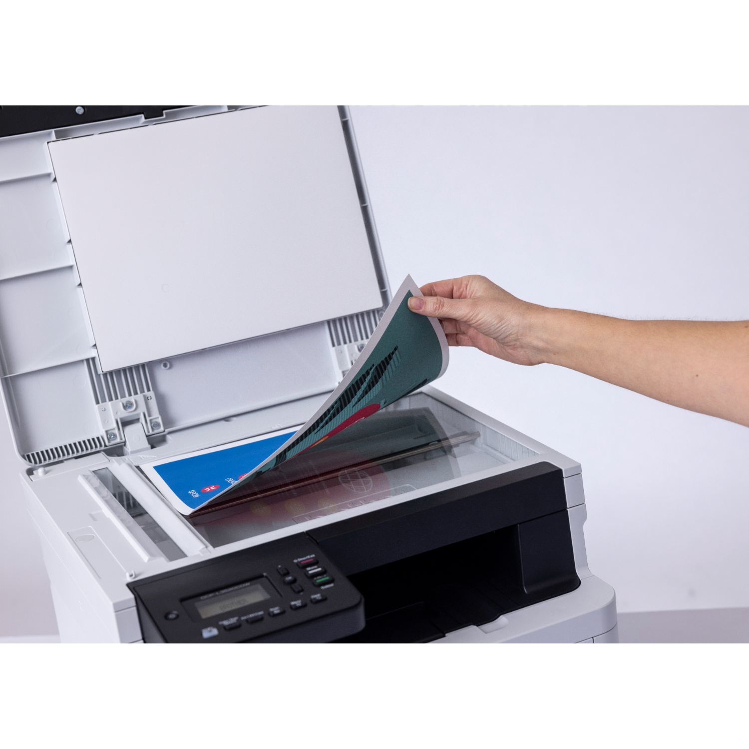 A person is scanning a document with a printer. The document is being fed into the machine.