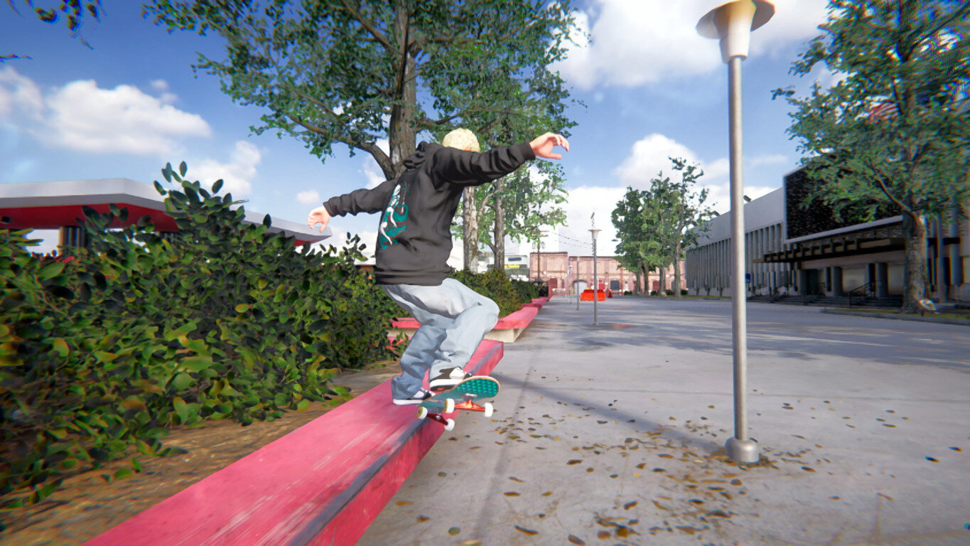 Skateboarder wykonujący grind na różowej krawędzi, z błękitnym niebem w tle.
