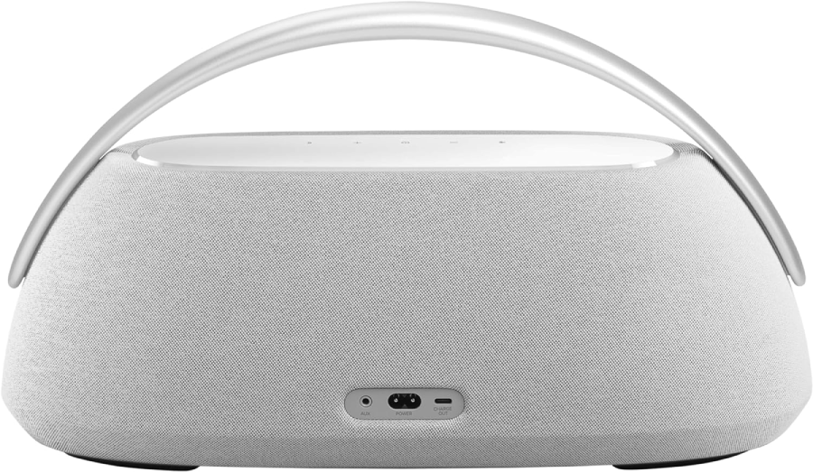 Altavoz blanco con asa. La parte trasera muestra los puertos AUX, alimentación y carga.