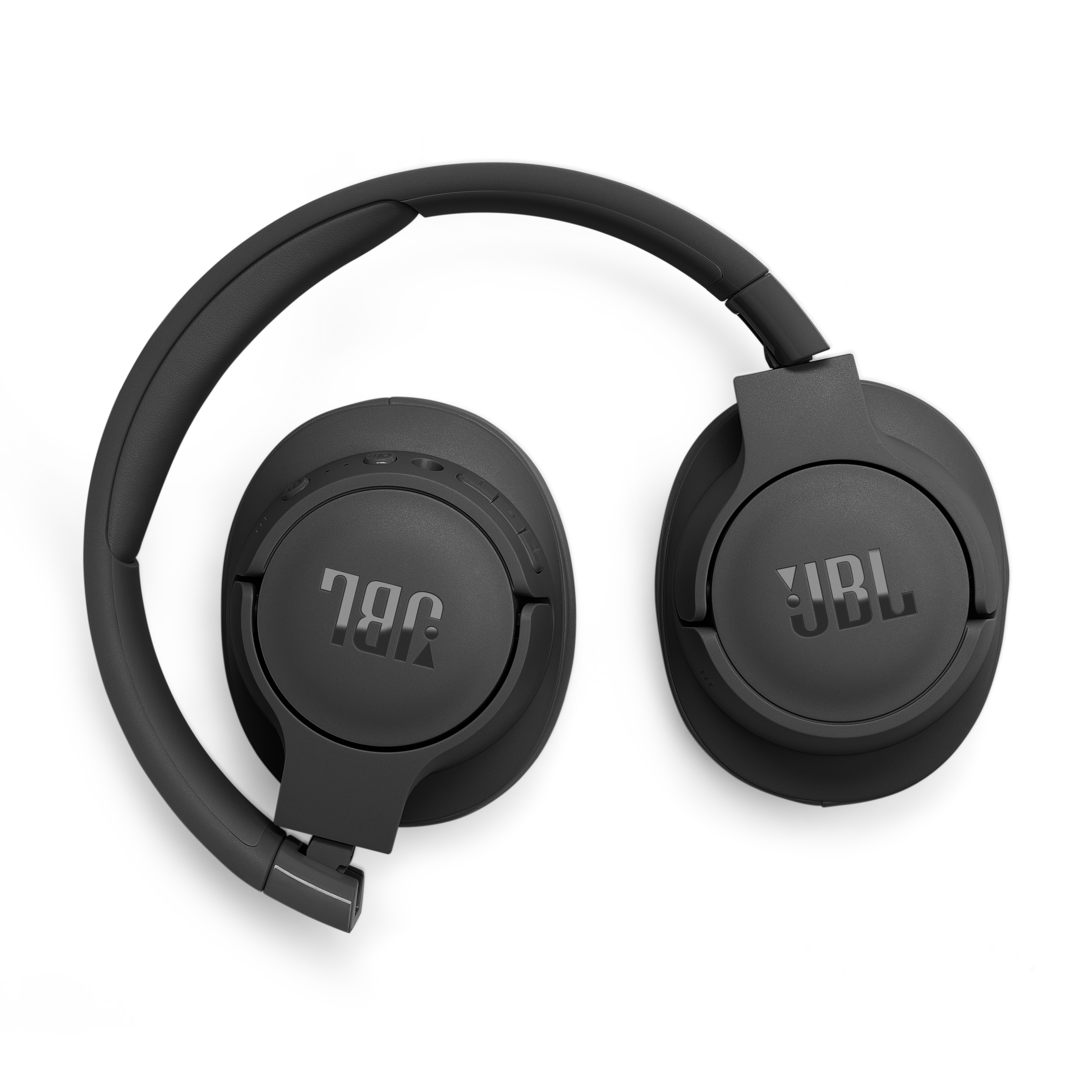 Siyah JBL kulaklıklar. Katlanmış ve beyaz bir yüzeye yerleştirilmiş. JBL logosu görünür.