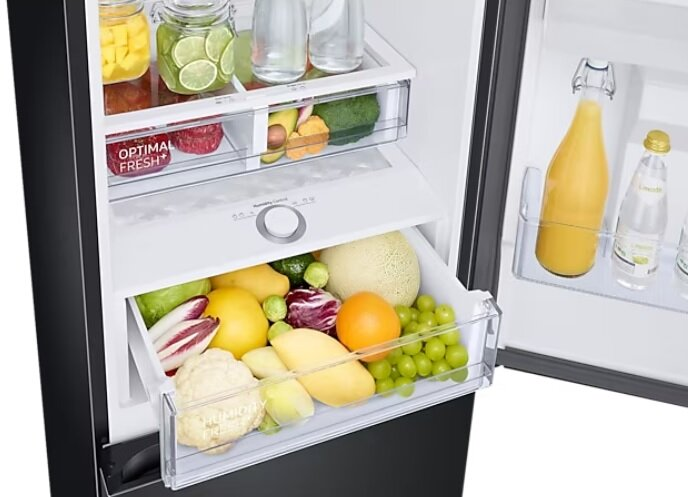 Wnętrze lodówki z otwartymi szufladami. Widoczne owoce, warzywa i butelki.