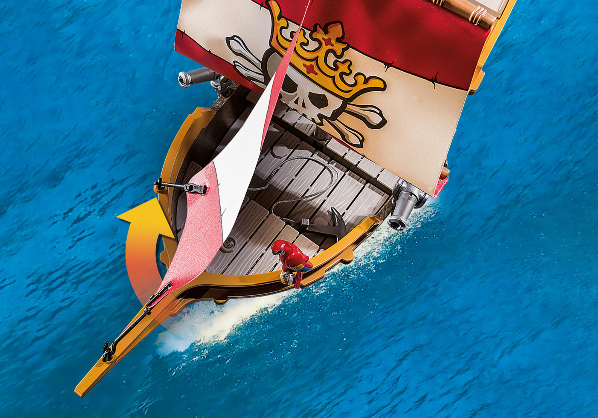 Spielzeug-Piratenschiff segelt auf blauem Wasser mit rotem und weißem Totenkopfsegel.