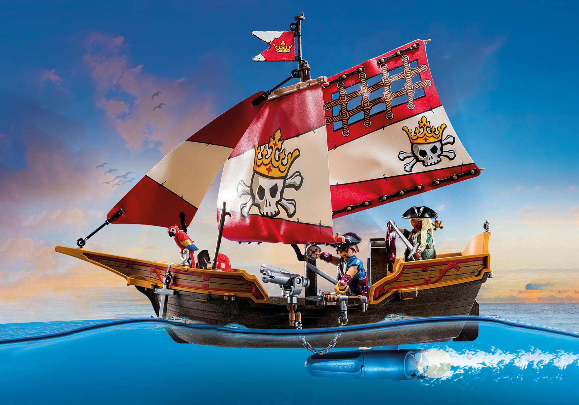 Spielzeug-Piratenschiff segelt auf dem Wasser, mit Piratenfiguren und einer Kanone. Der Himmel ist blau mit Wolken.