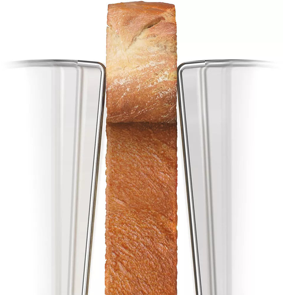 Bochenek chleba między dwoma srebrnymi tosterami.