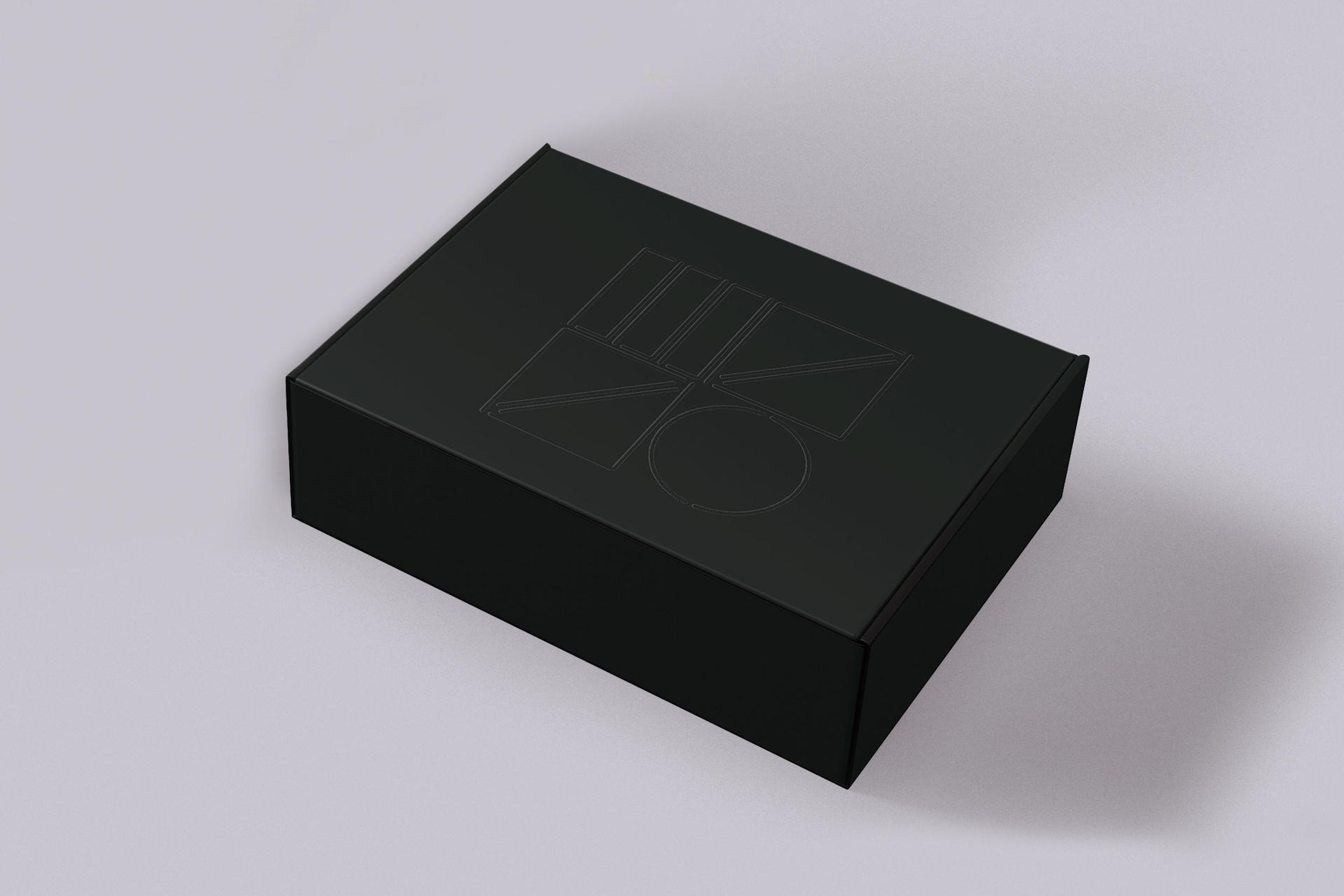 Eine schwarze Box mit geometrischen Formen auf der Oberseite, platziert auf einer weißen Oberfläche.