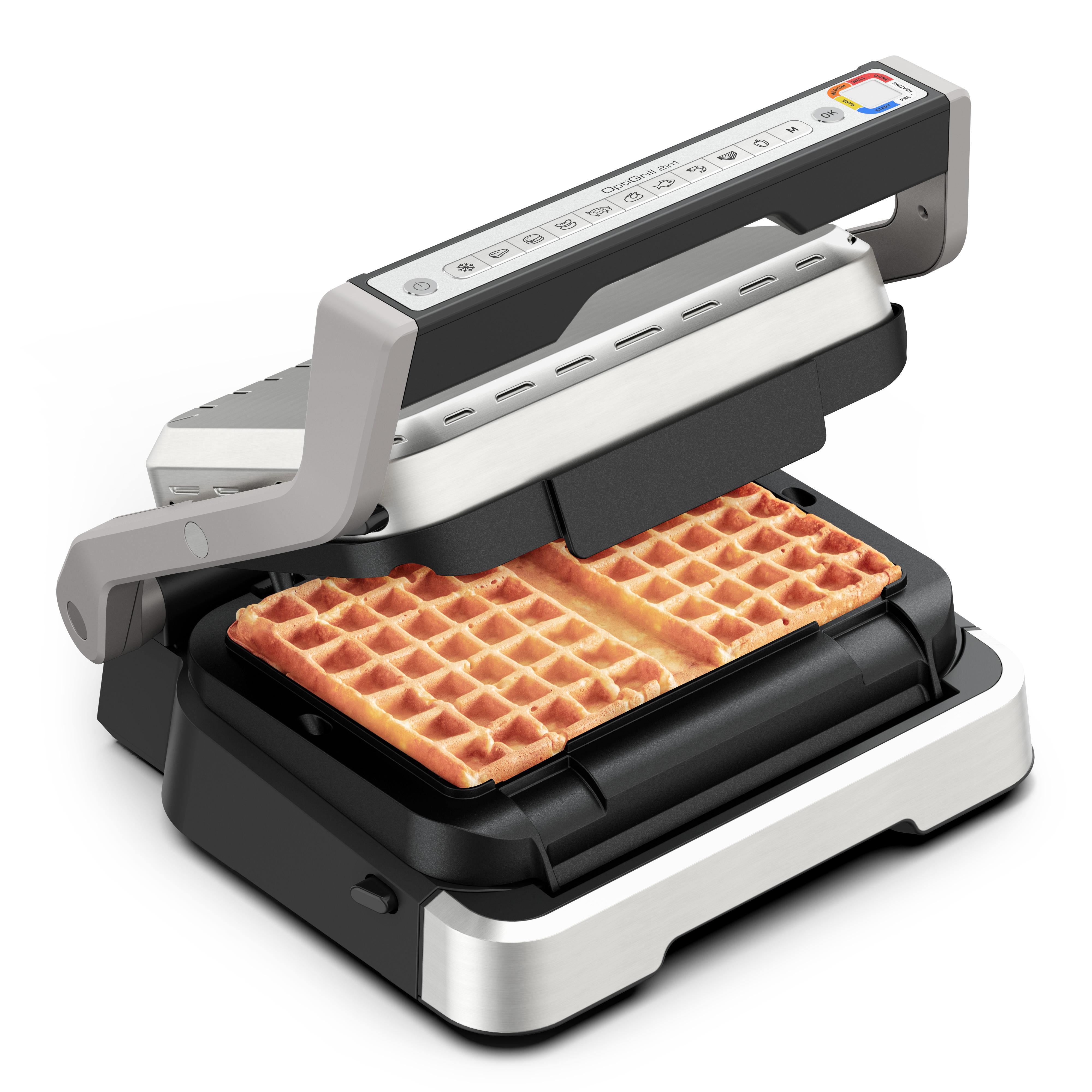 Ein Waffeleisen, offen, mit einer gebackenen Waffel darin. Es steht auf einer weißen Oberfläche.