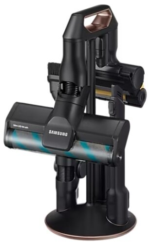 Odkurzacz bezprzewodowy z wieloma nakładkami na czarnej stacji ładującej. Widoczne logo Samsung.