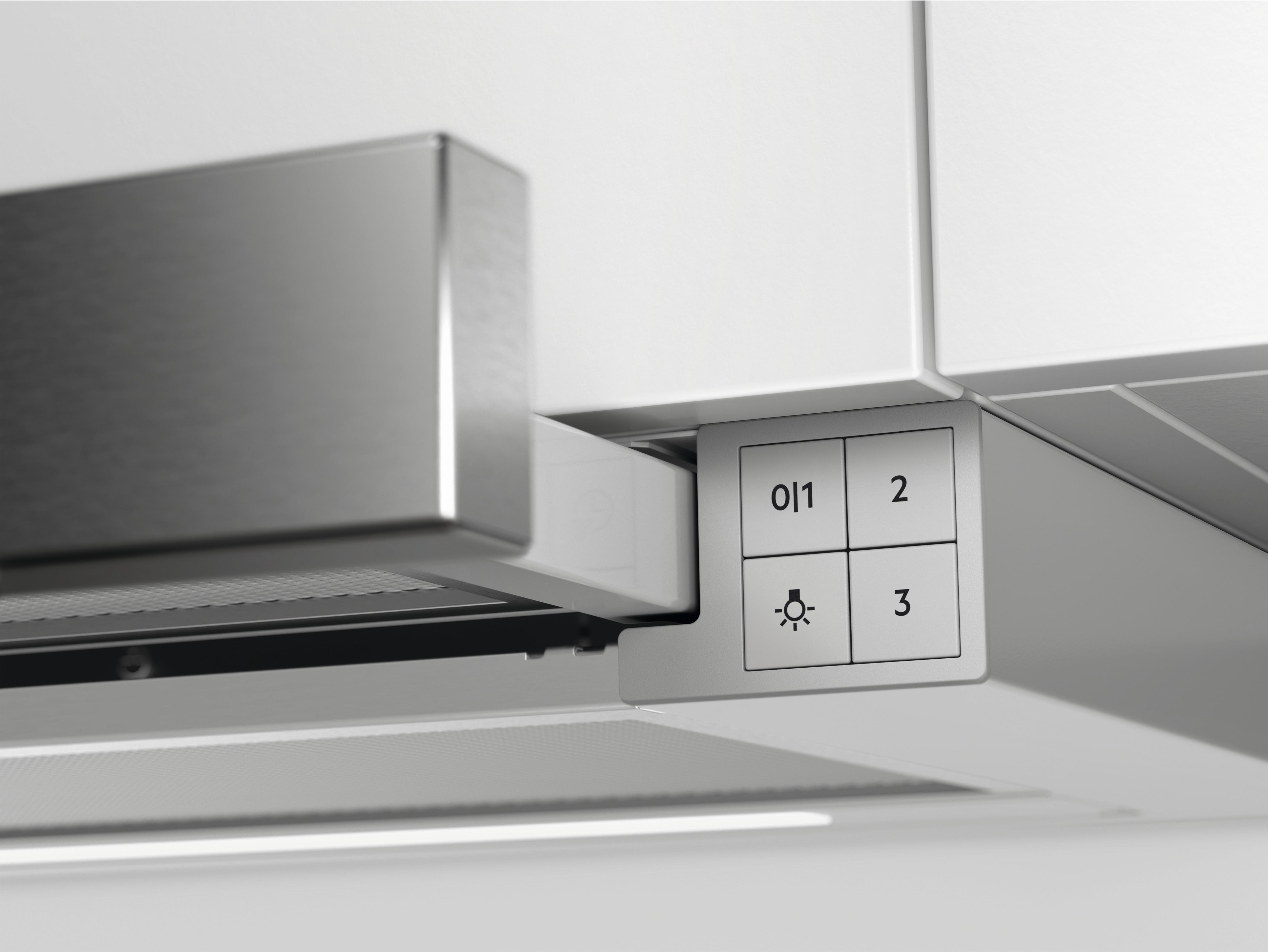 Nahaufnahme eines Bedienfelds unter einem Schrank mit Tasten, die mit Zahlen und einem Lichtsymbol beschriftet sind.