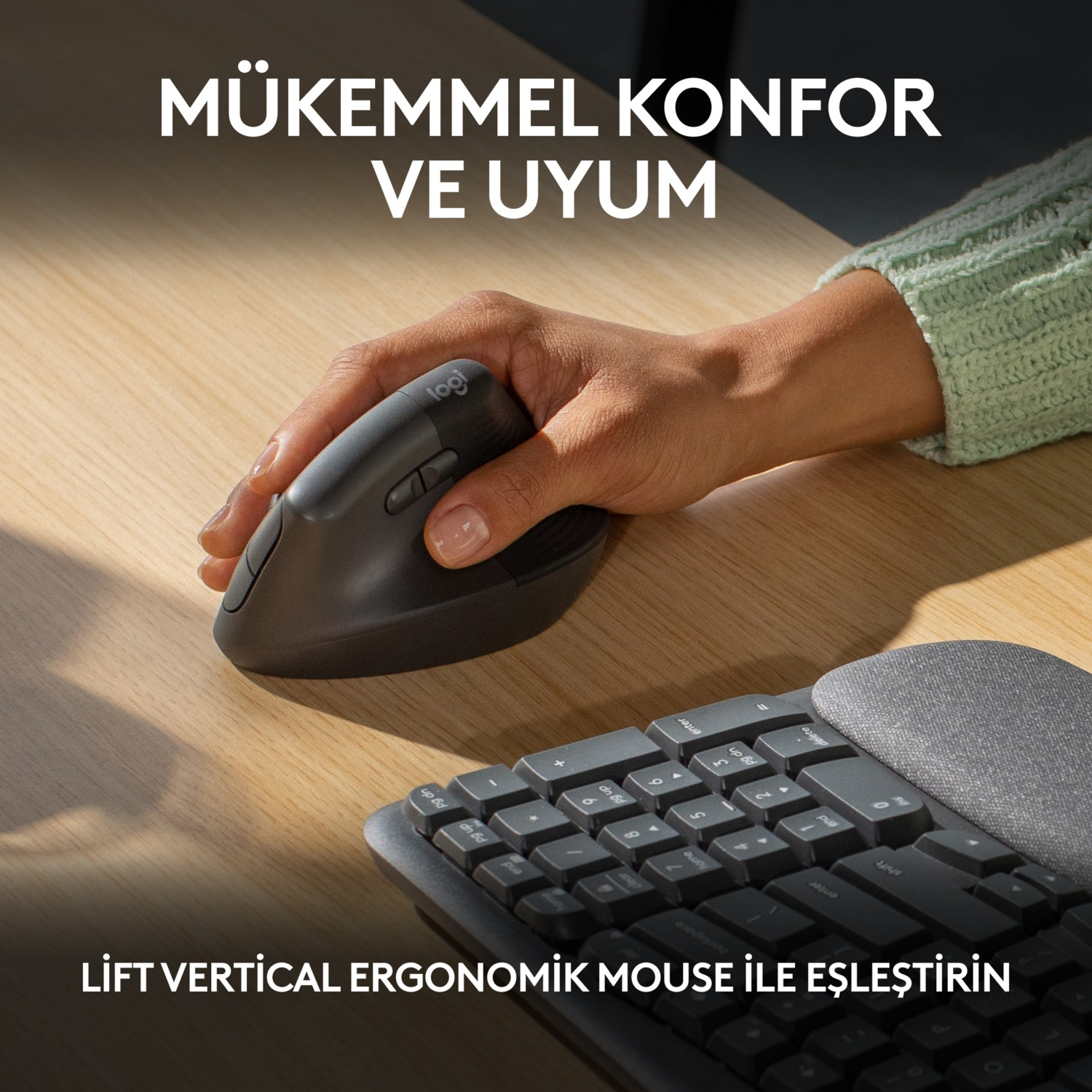 Bir kişinin eli, bir klavyenin yanında, ahşap bir masada siyah ergonomik bir dikey fare kullanıyor.