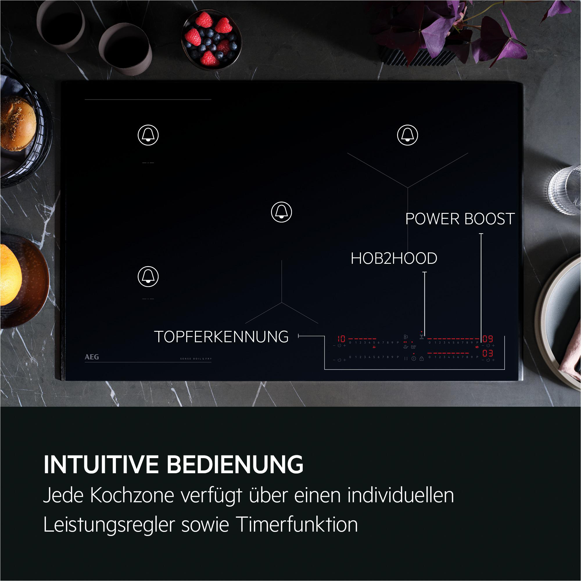 Schwarzes Induktionskochfeld mit Kochfeld-Symbolen. Rote Digitalanzeige. Essen und Utensilien auf der Oberfläche.