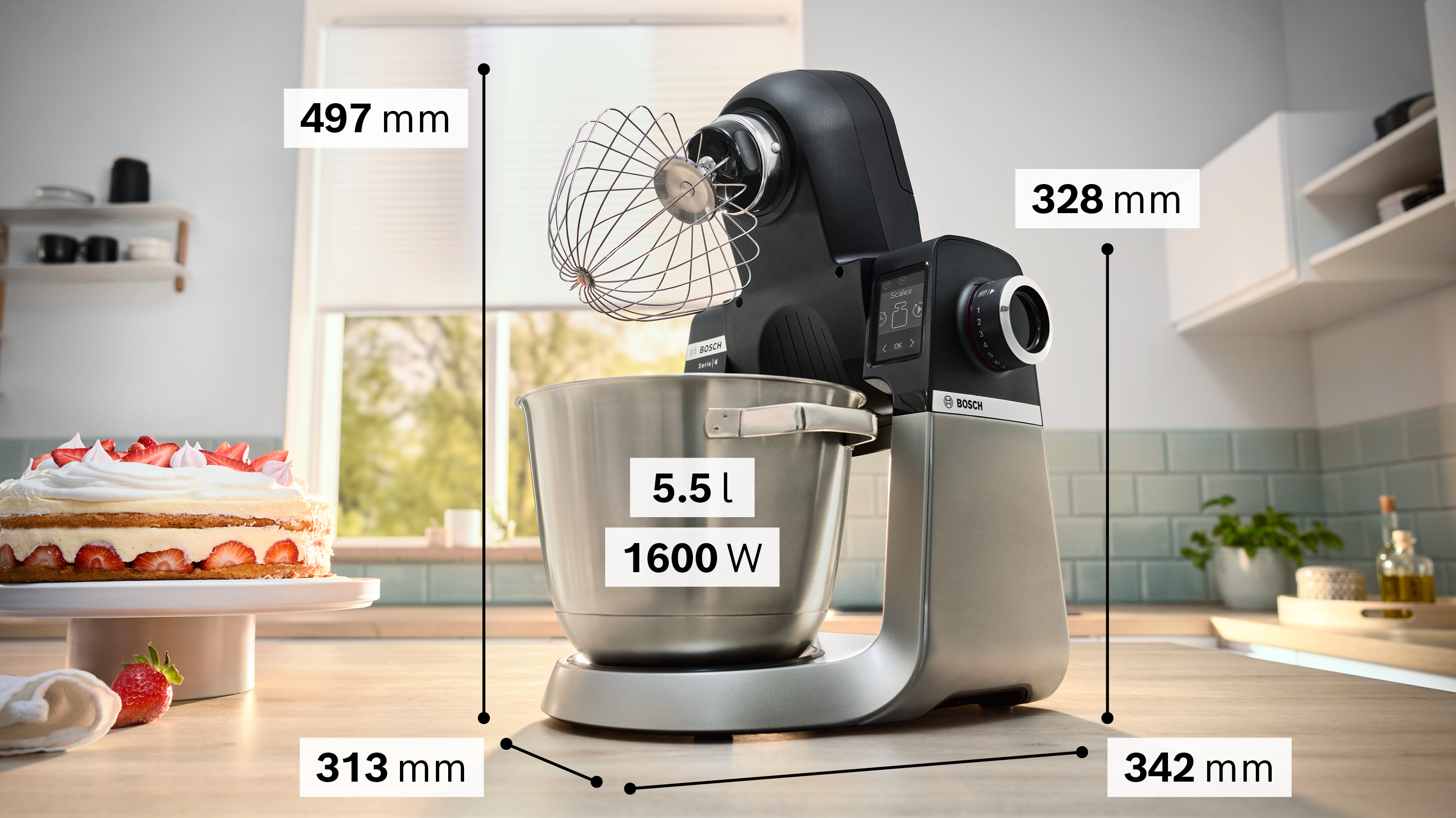 Küchenszene: Bosch Küchenmaschine mit Maßen. Kuchen, Fenster im Hintergrund. Maße sind angezeigt.