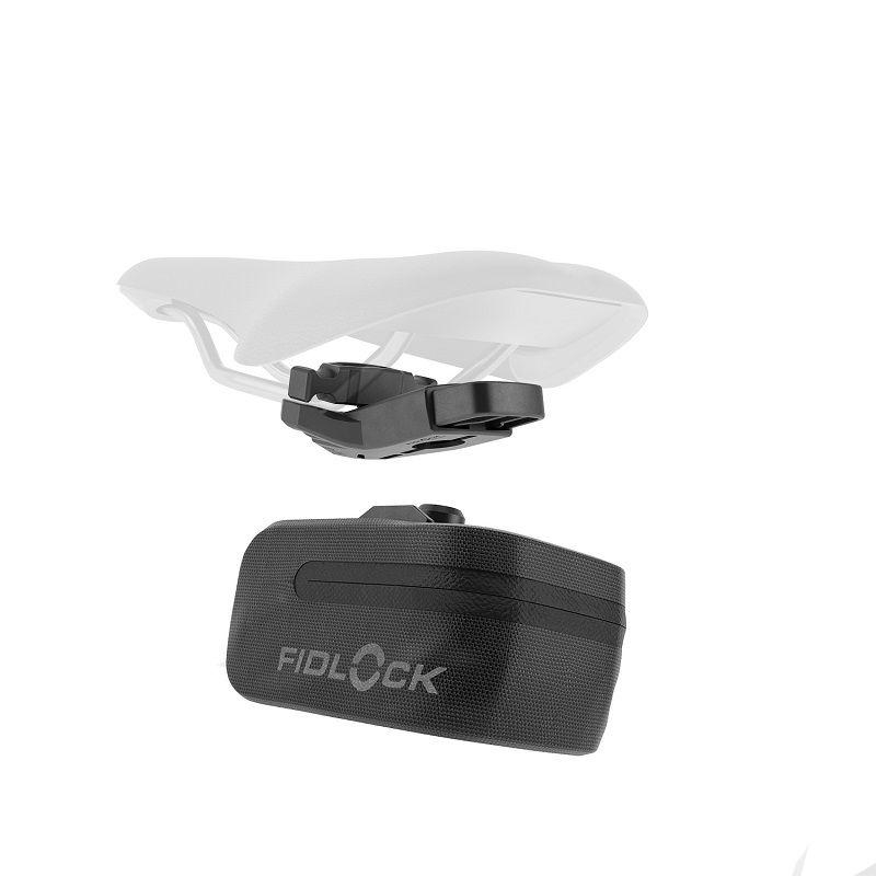 Ein weißer Fahrradsattel und ein schwarzes Fidlock-Teil über einem schwarzen Fidlock-Behälter.