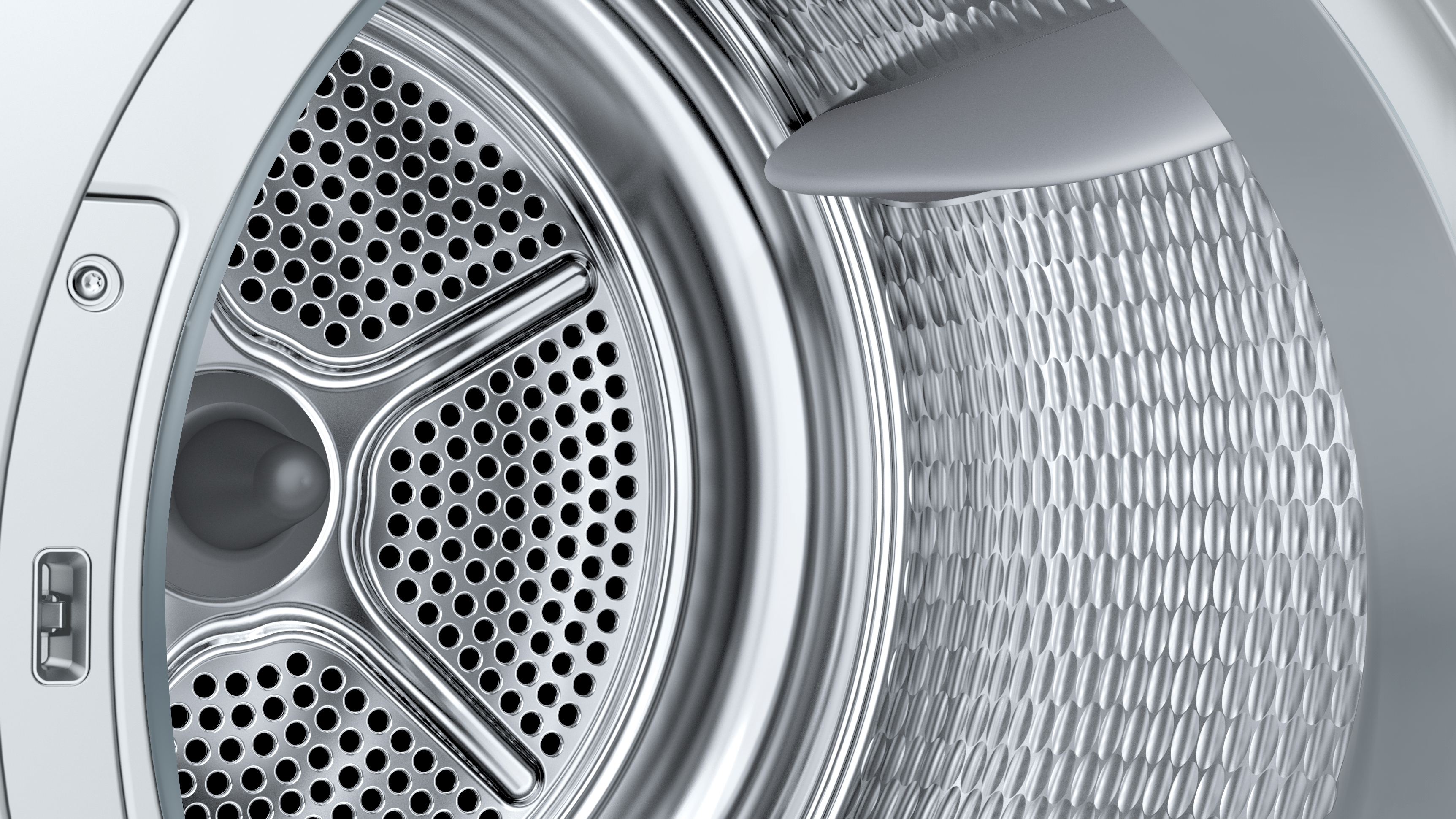 Nahaufnahme des Innenraums einer Waschmaschinentrommel mit Perforationen und silberfarbenem Design.