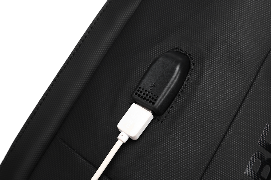 Fekete hátizsák USB töltőporttal és fehér töltőkábellel.