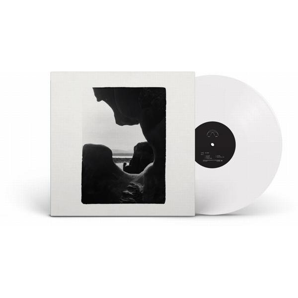 Eine weiße Vinylplatte in einer Hülle mit einer schwarz-weißen Landschaftsfotografie.