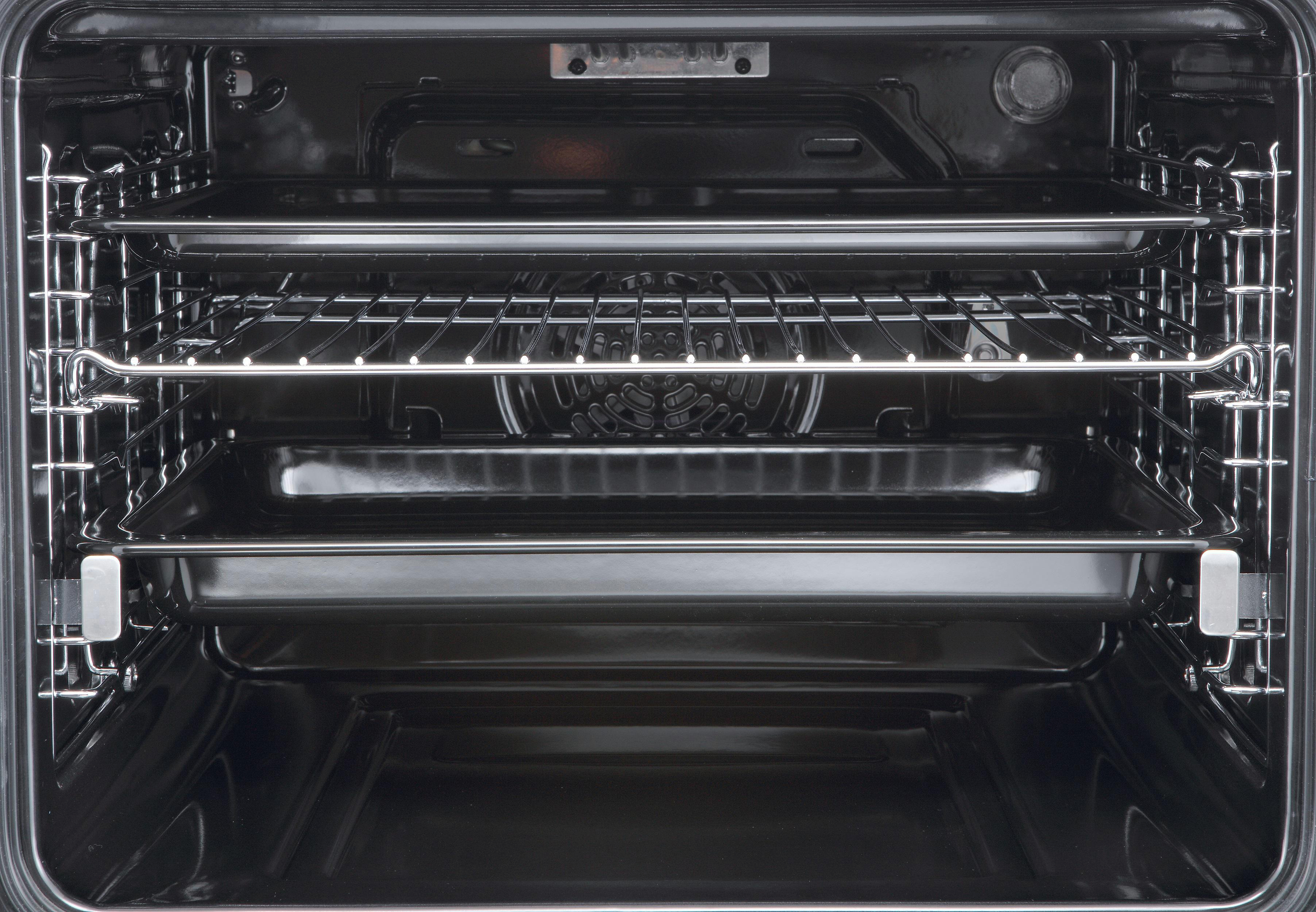 Innenansicht eines Ofens mit Rosten, einem Metallgrill und einem Backblech.