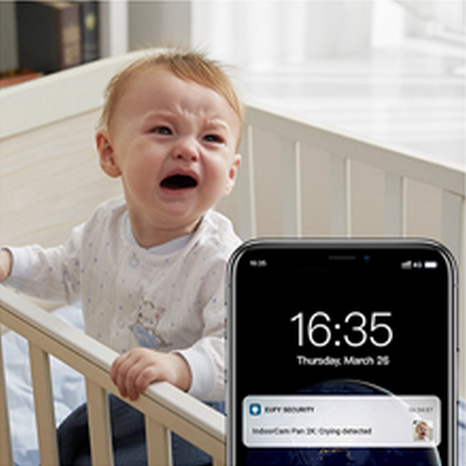 Bébé pleurant dans un berceau ; le téléphone affiche une notification : IndoorCam 2K, pleurs détectés.