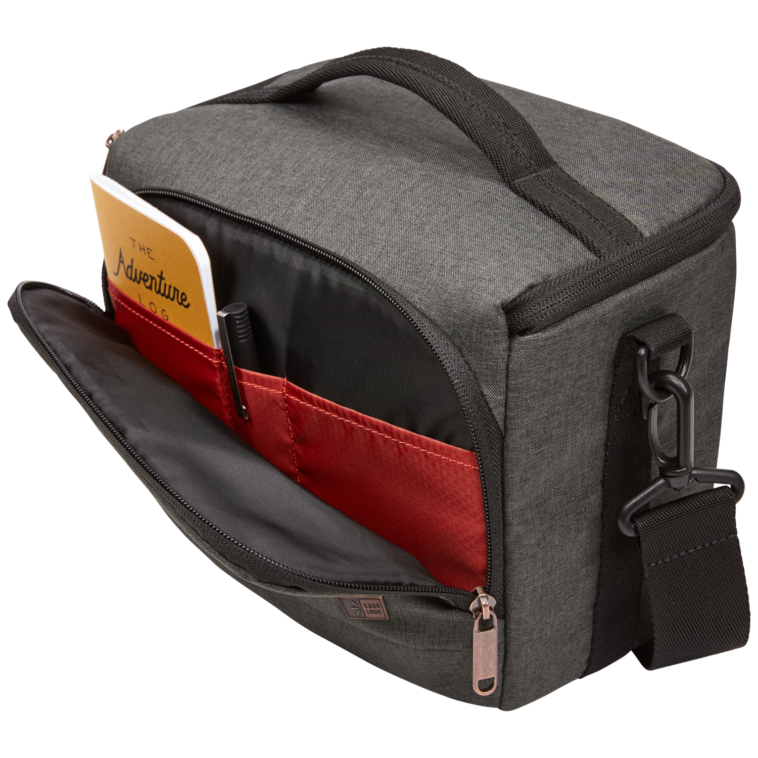 Open gray camera bag with a notebook and pen in a red pocket. Black strap and handle are visible.