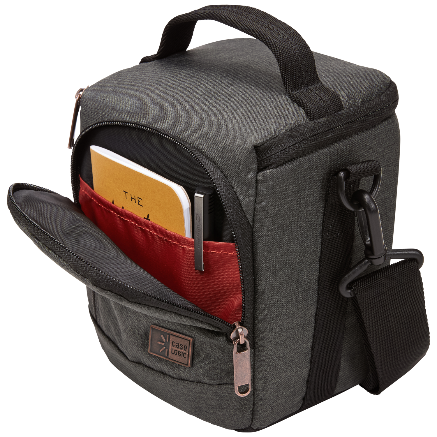 Gray camera bag, open to reveal a notebook and pen inside a red pocket with a black strap.
