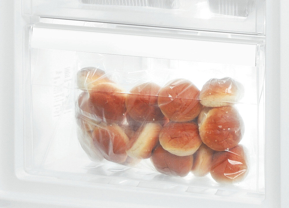 Plastikowa torba pełna bułek w lodówce.