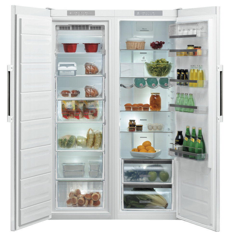 Biała lodówko-zamrażarka z otwartymi drzwiami, pokazująca półki z jedzeniem. Artykuły obejmują warzywa, butelki i słoiki.