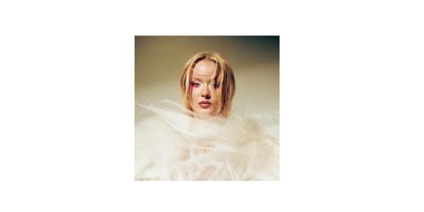 Frau mit blonden Haaren, rotem Augen-Make-up und flauschigem weißen Pelz.