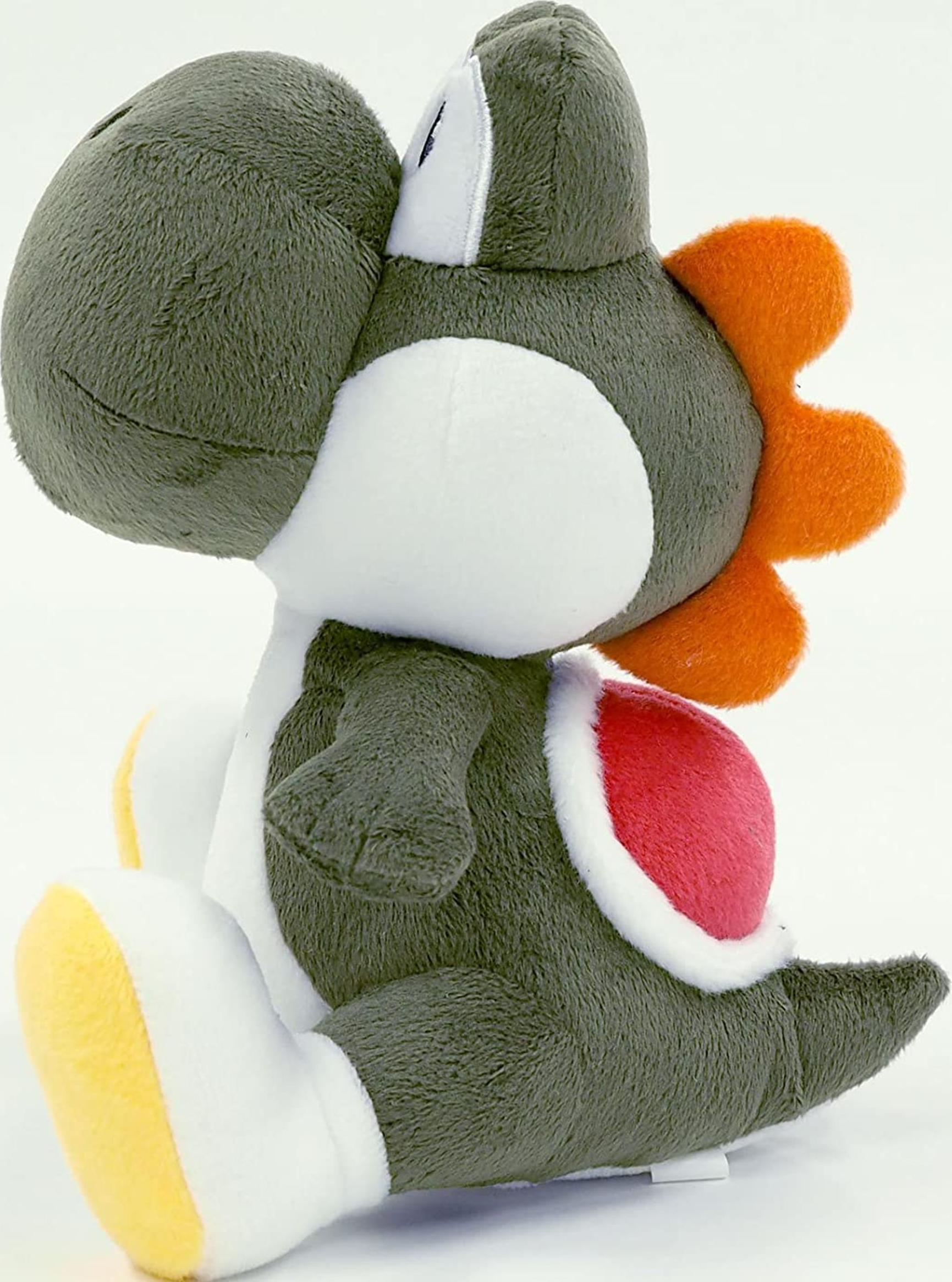Peluche di Yoshi in vista laterale, corpo verde, pancia bianca e guscio rosso.