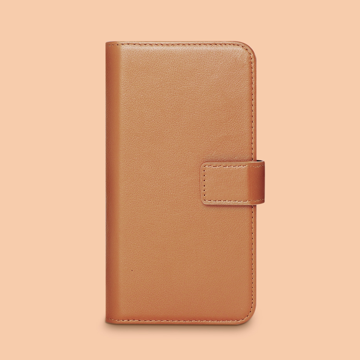 Een gesloten bruine leren telefoonhoesje met een magnetische sluiting. De achtergrond is perzikkleurig.