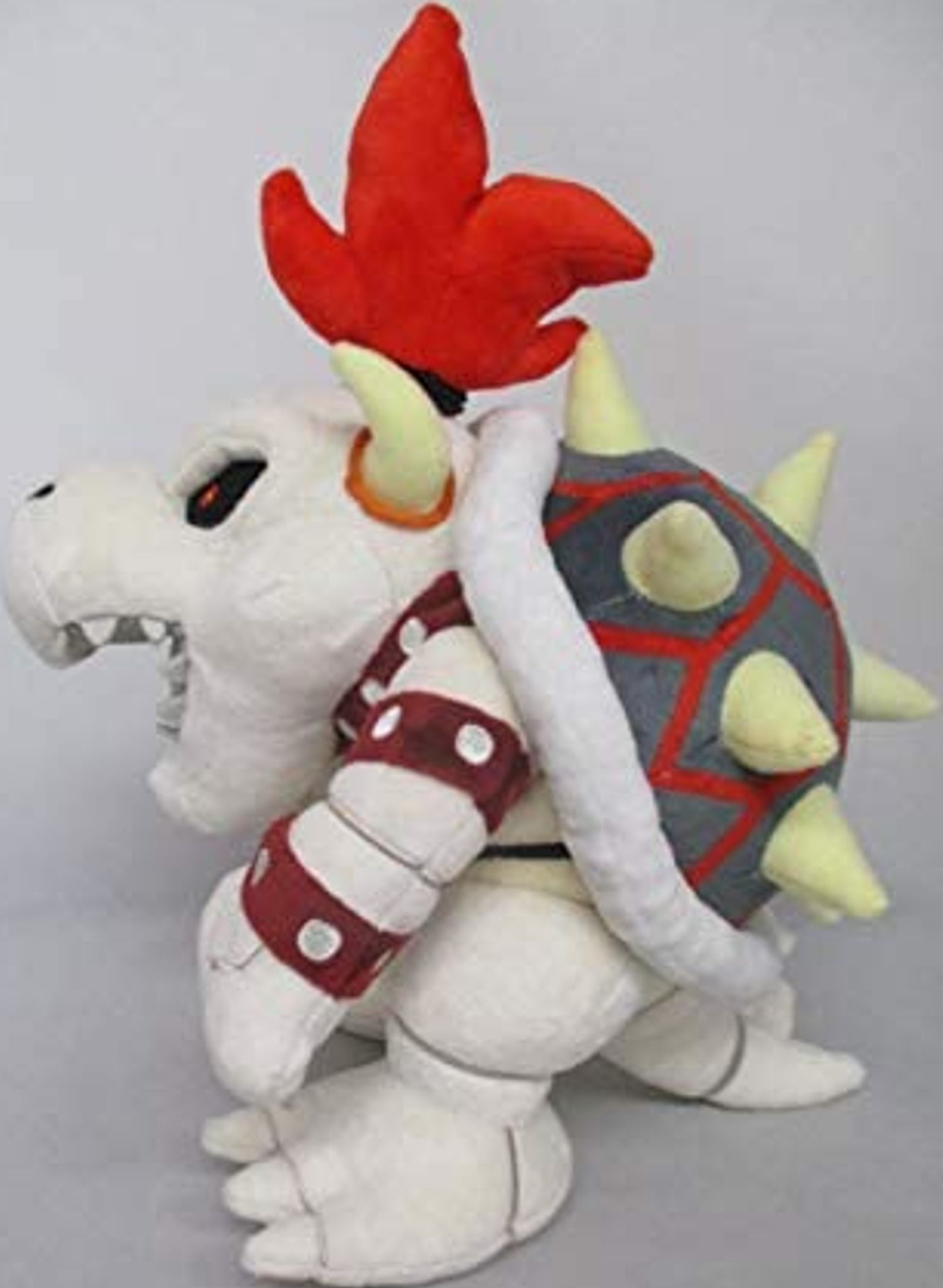 Peluche Bowser de la série Super Mario, blanc avec des accents rouges et des pics.
