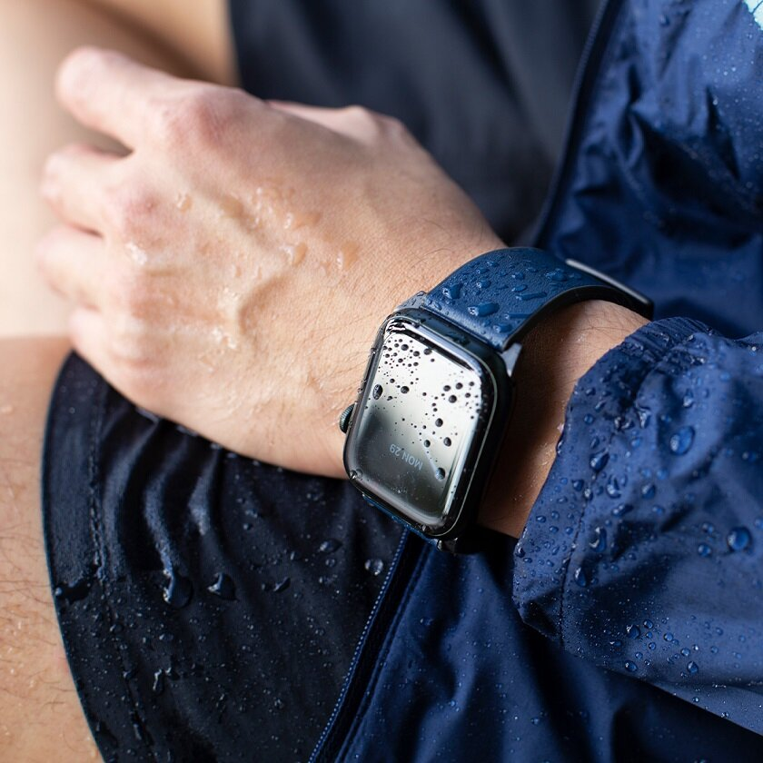 Męski nadgarstek ze smartwatchem, z kroplami wody na ekranie i nadgarstku.