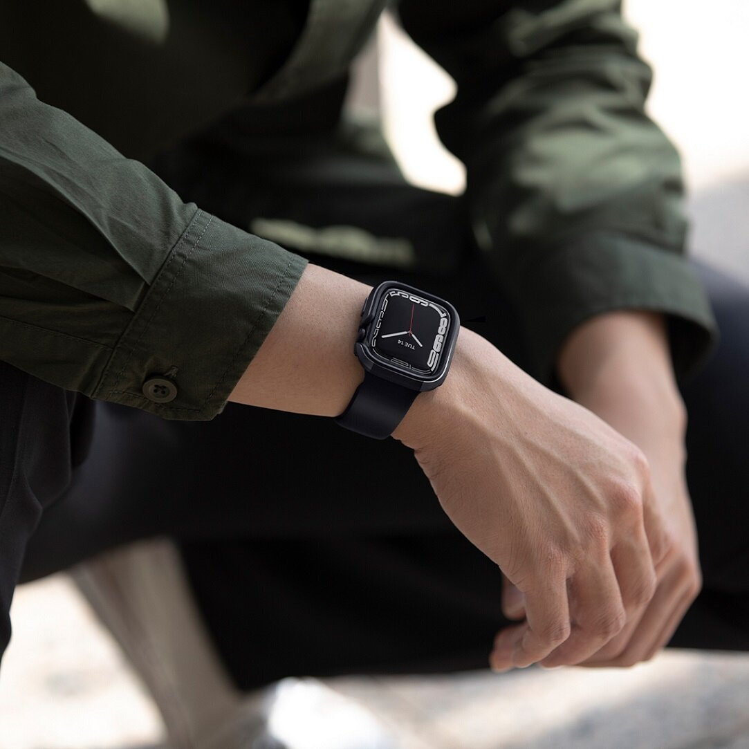 Osoba nosząca czarny Apple Watch na nadgarstku. Zegarek ma czarny pasek.