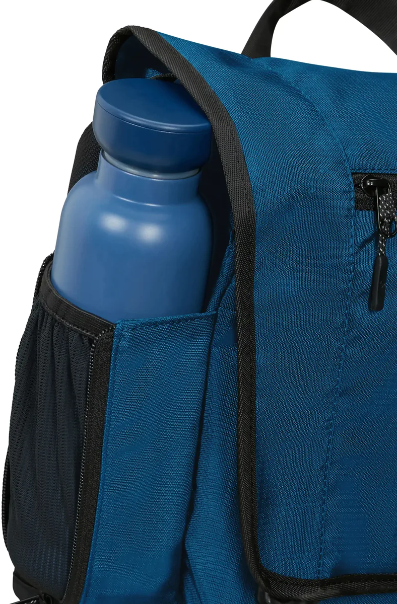 Ein blauer Rucksack mit einer Wasserflasche in der Seitentasche. Schwarze Paspel.