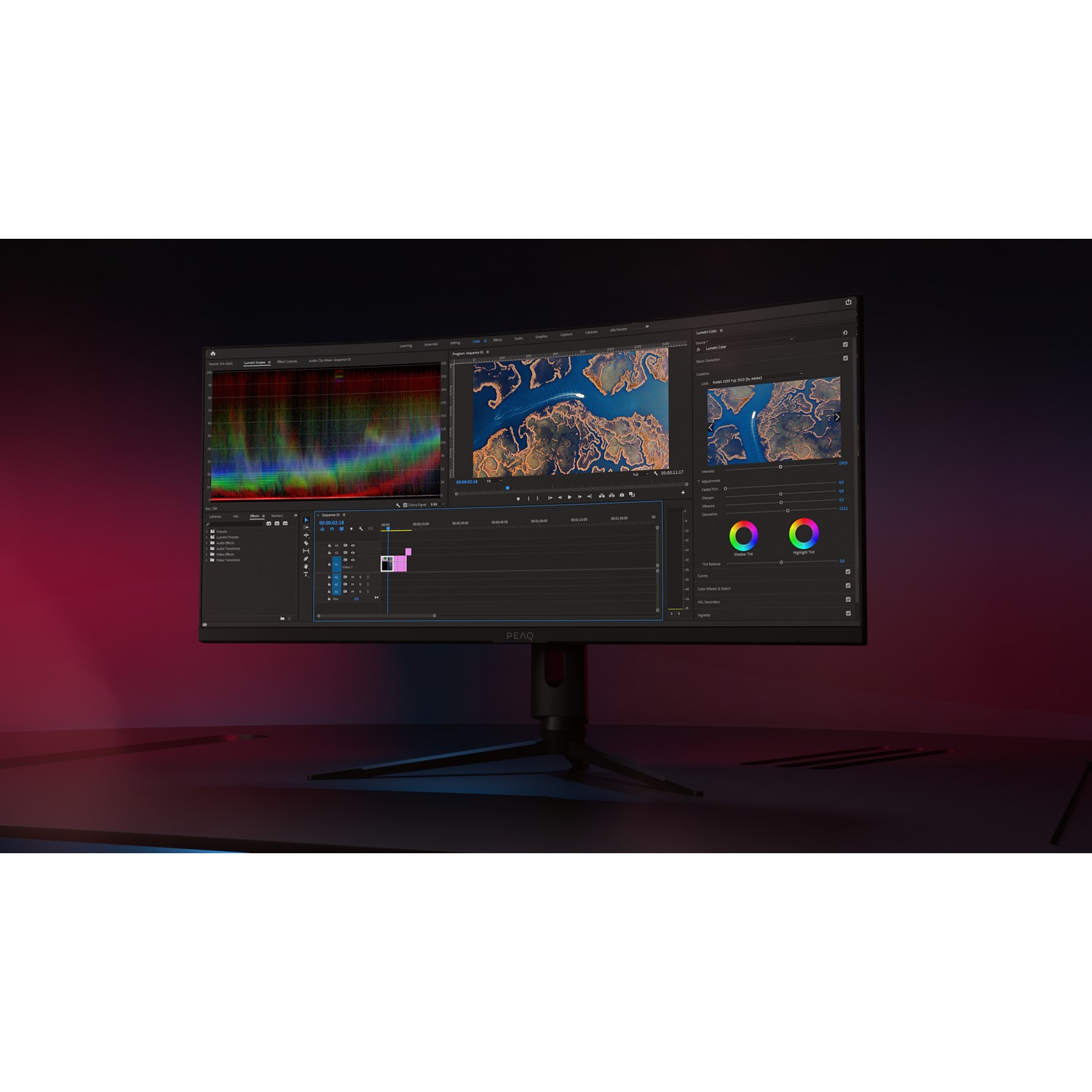 Curved monitor showing a video editing interface, color grading, and a dark background.