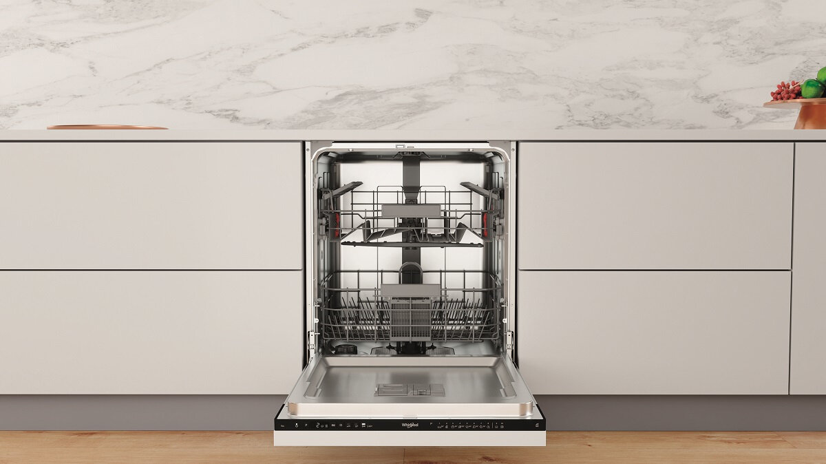 Biała kuchnia z otwartą zmywarką. Drzwi są otwarte, widać wewnętrzne kosze.