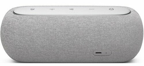 Szary głośnik z przyciskami na górze i portem ładowania na dole. Głośnik ma materiałową osłonę.
