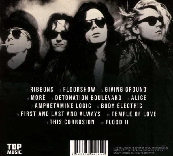 Vier Personen in Schwarz, mit Sonnenbrillen, schauen in die Kamera. Albumcover mit Titeln.