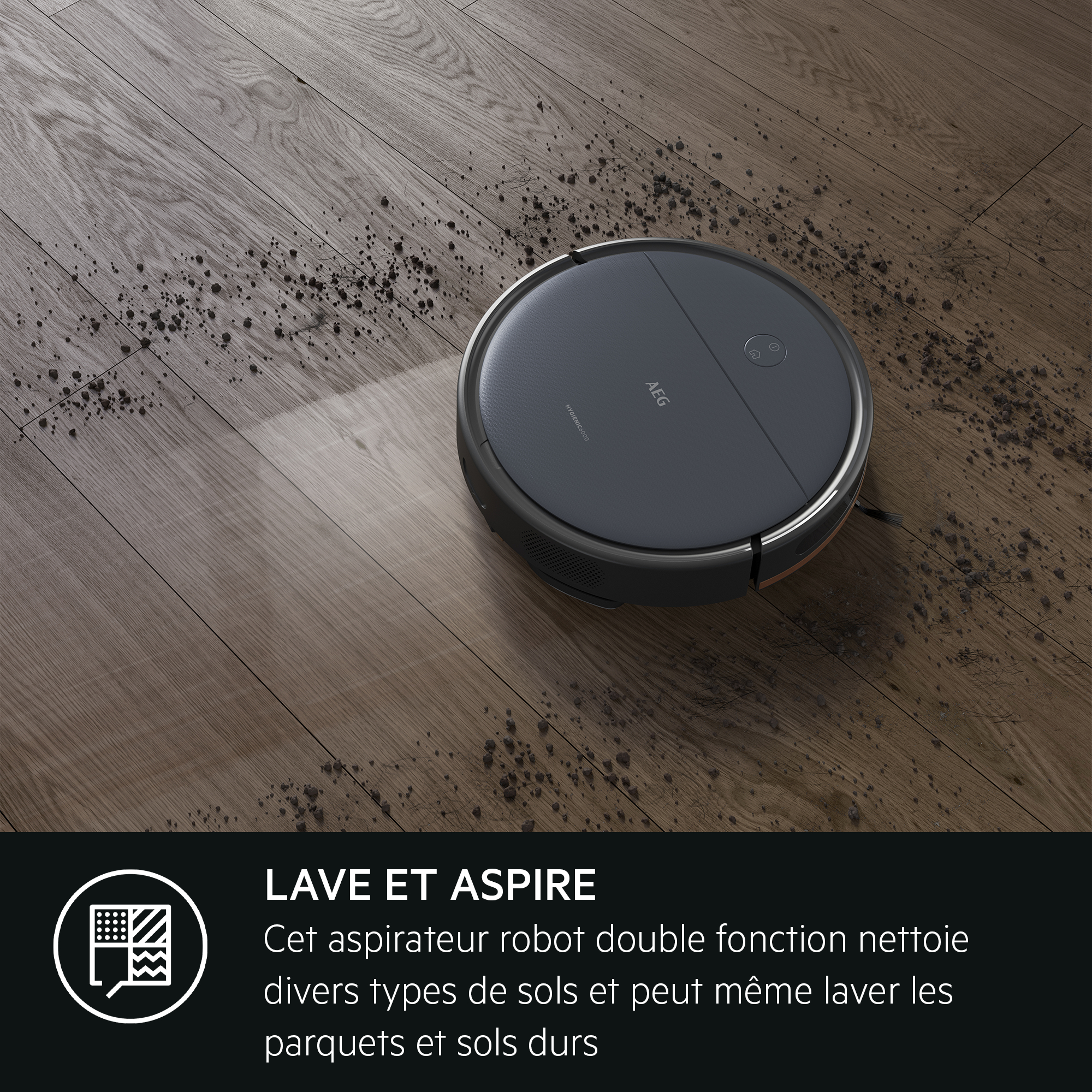 Robot aspirateur sur sol en bois, en train de nettoyer. Texte dit 'Lave et aspire'.